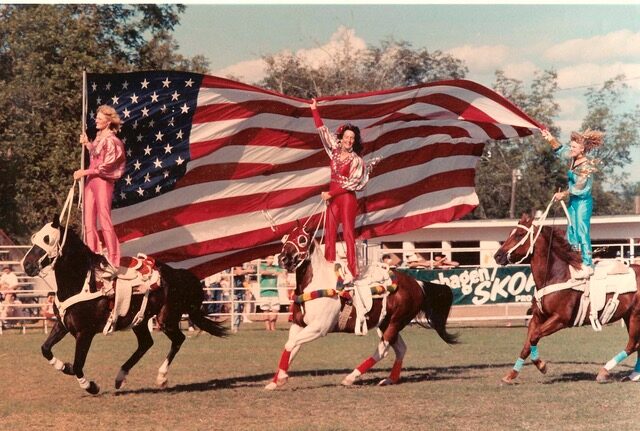 Linda riding with flag